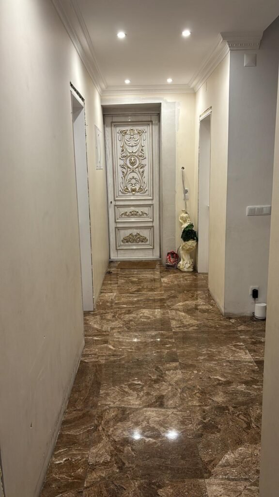 Corredor em mármore com porta ornamentada