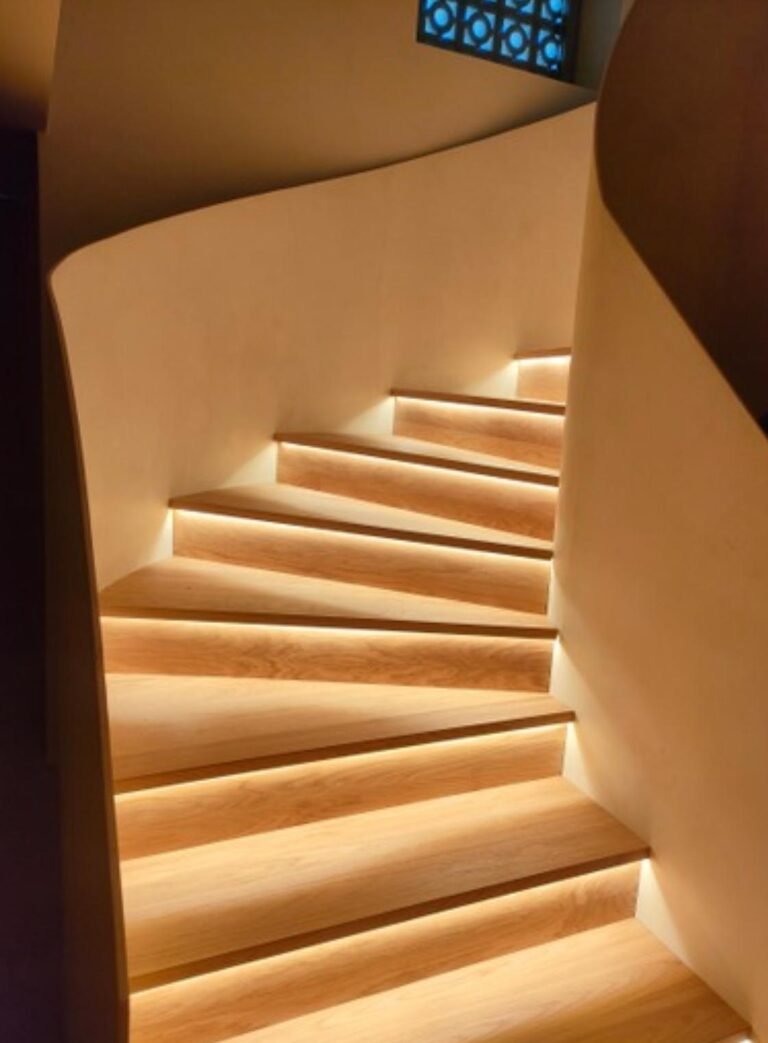 Escada interior iluminada com acabamentos em madeira