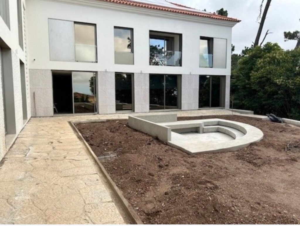Moradia reabilitada com fachada branca e piscina