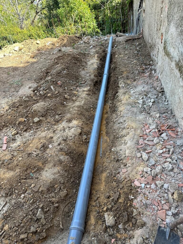 Vala com tubagem de drenagem em PVC junto a muro